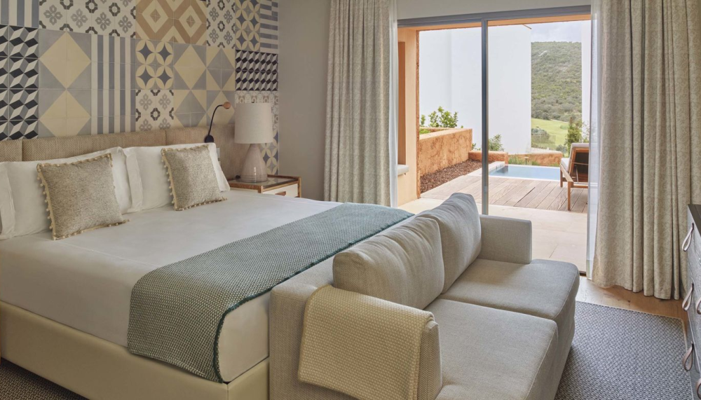A king bed ina room with a couch, dresser, and a patio at Ombria Algarve