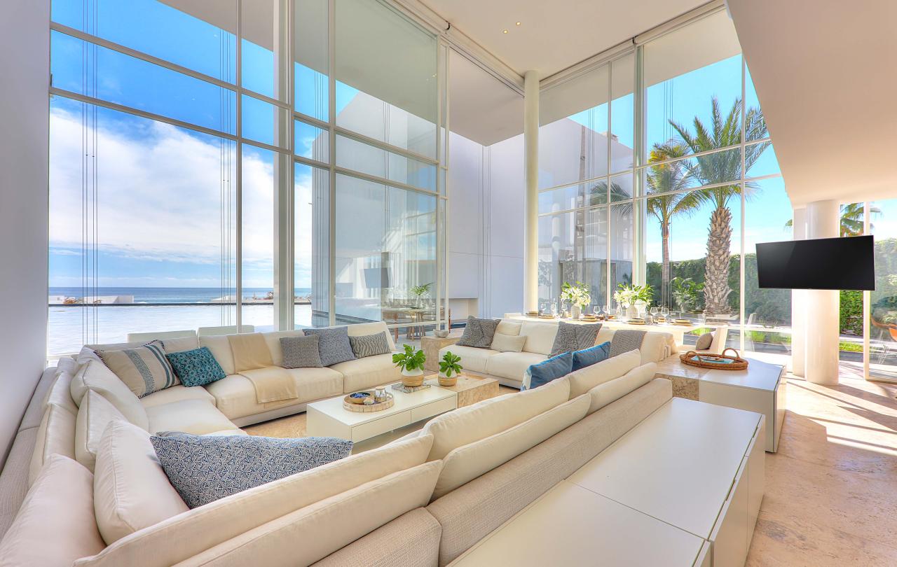 los cabos waterside villa living space with a large sofa and floor to ceiling windos=ws