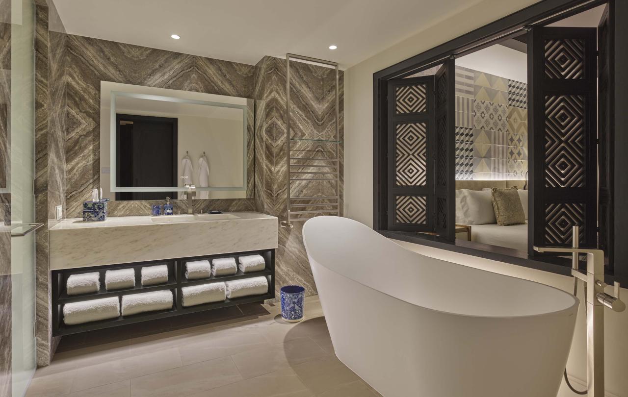 Bathroom with large vanity, bathtub, and window to room