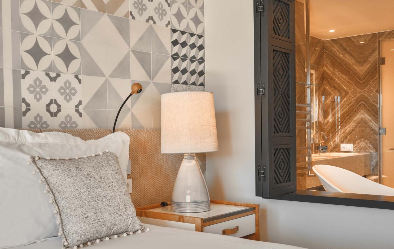 Bedroom with king bed and nightside table with a window to the bathroom open
