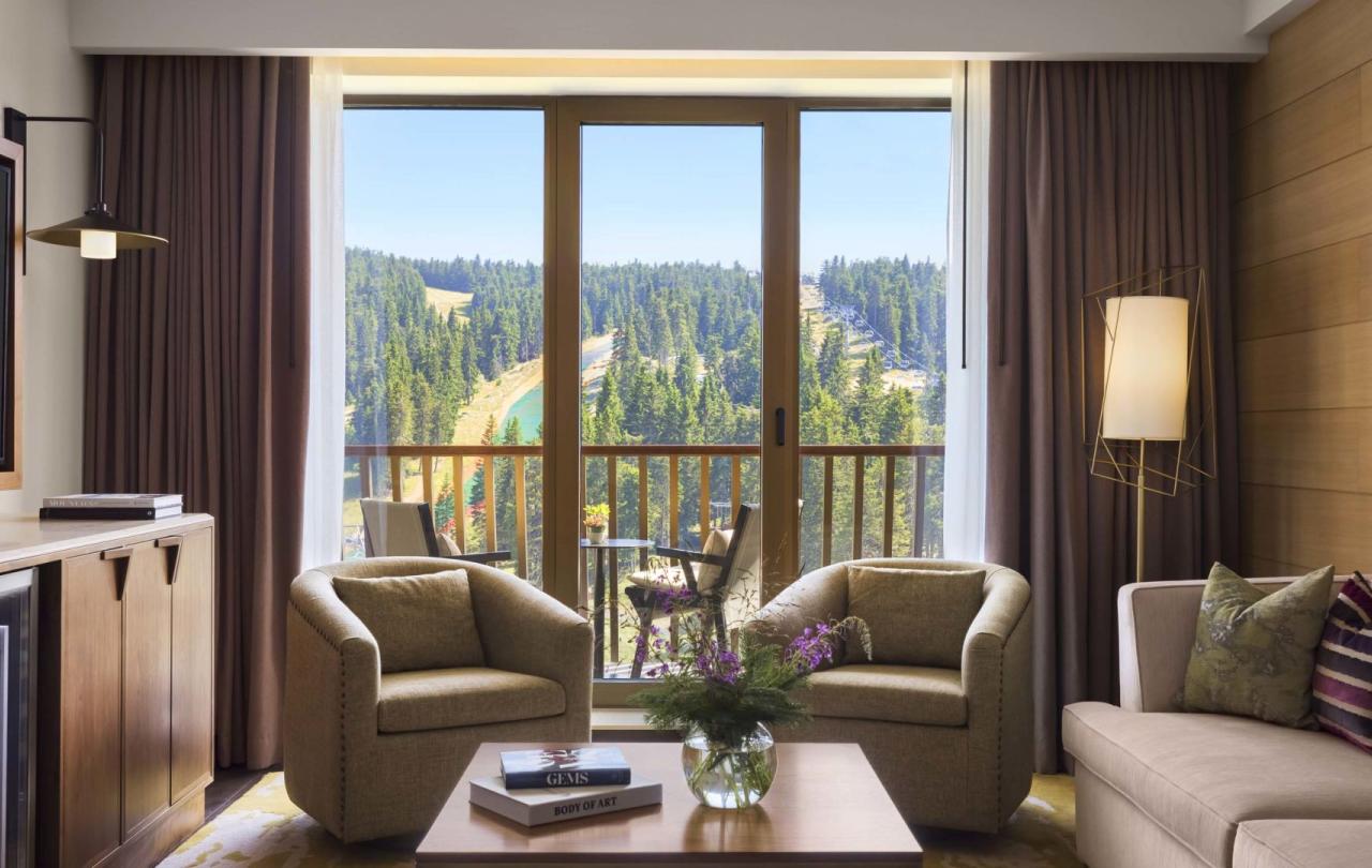 The living space with a TV, couch, and two chairs in a suite at Viceroy Kopaonik Serbia