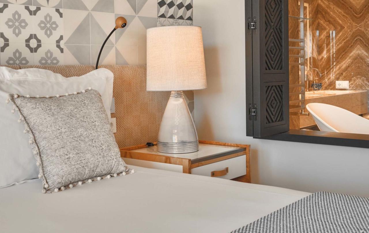 The corner of a bed and the night stand in a deluxe king room at Viceroy Ombria Algarve