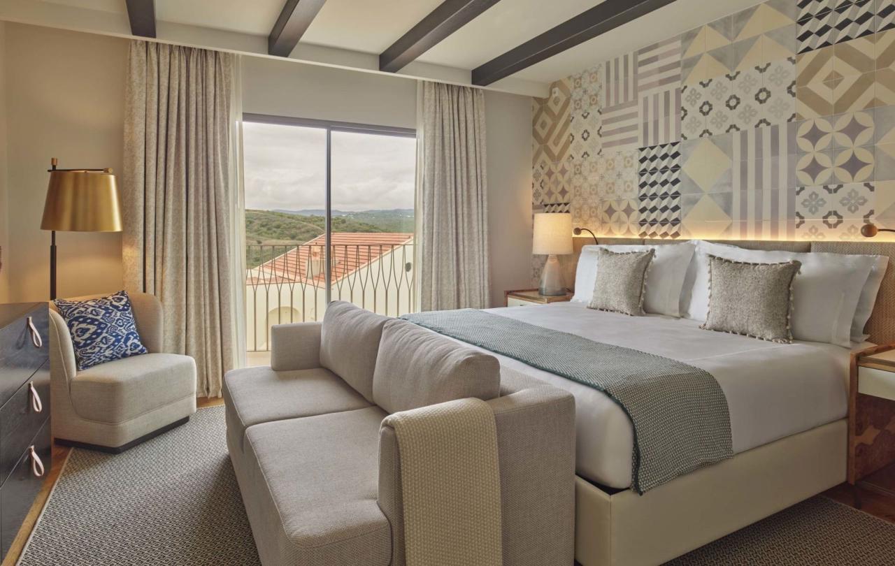 A bed with a couch and a chair in a one bedroom suite at Viceroy Ombria Algarve