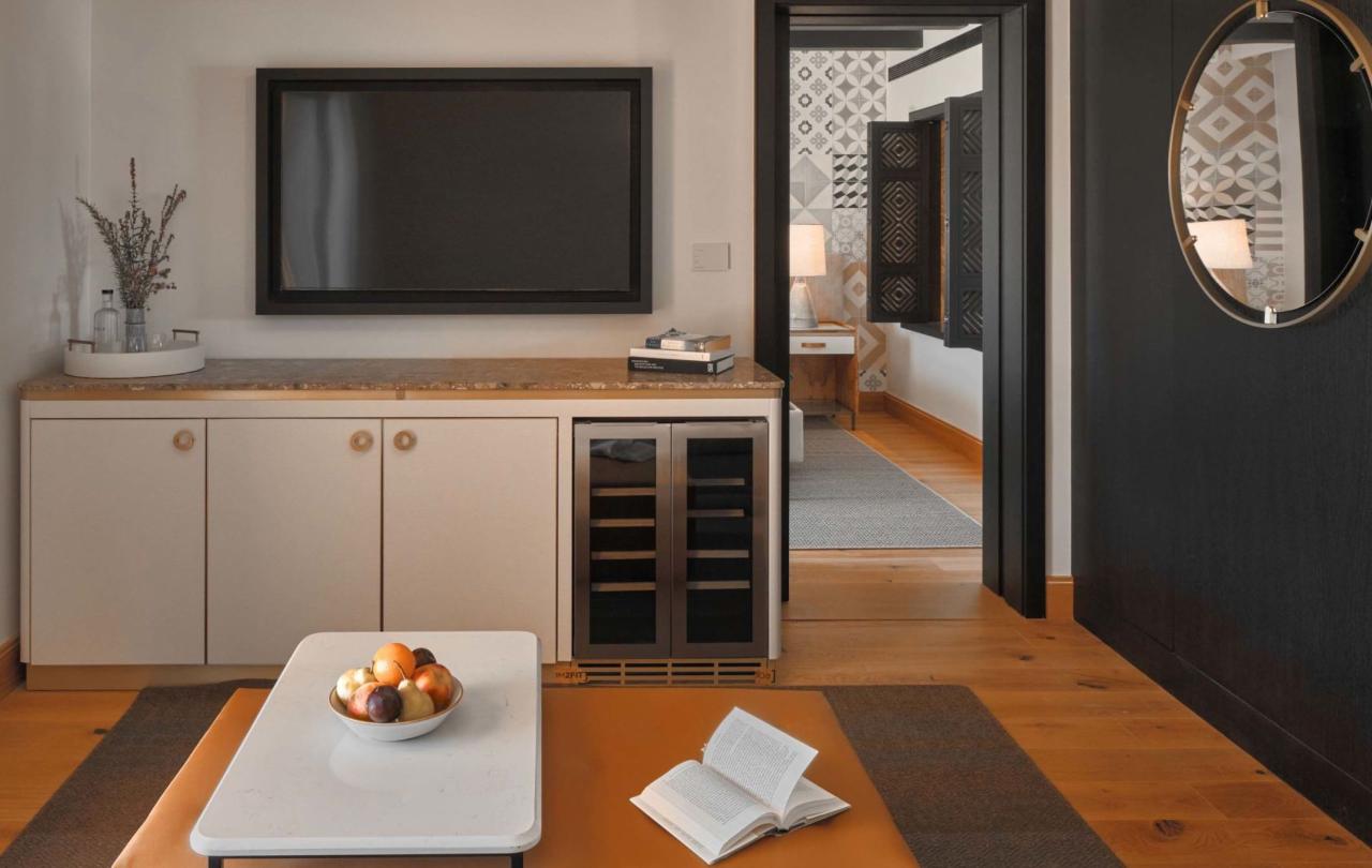 A coffee table, credenza with a tv on top in a one bedroom suite at Viceroy Ombria Algarve