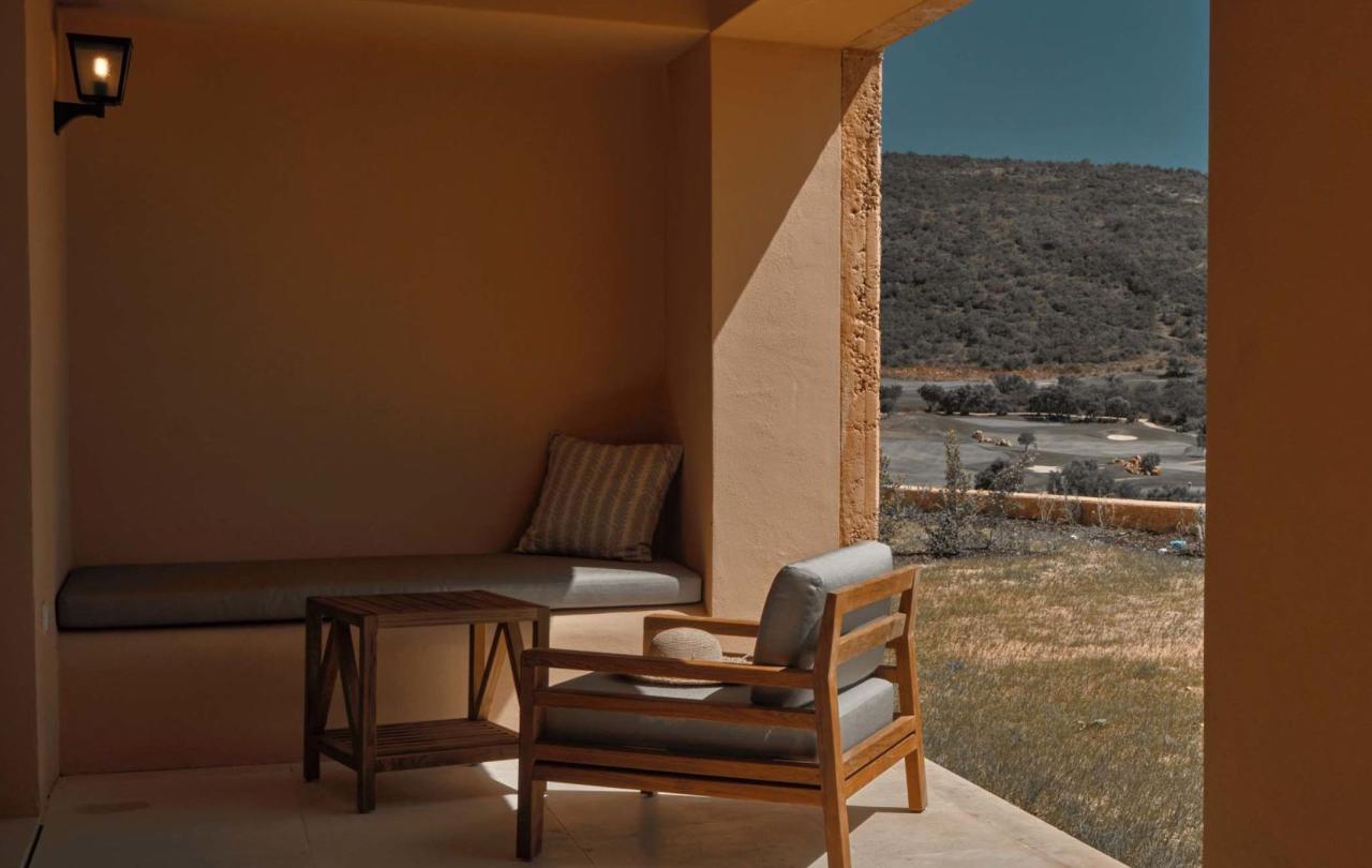 A covered terrace with bench seating and a chair at Viceroy Ombria Algarve