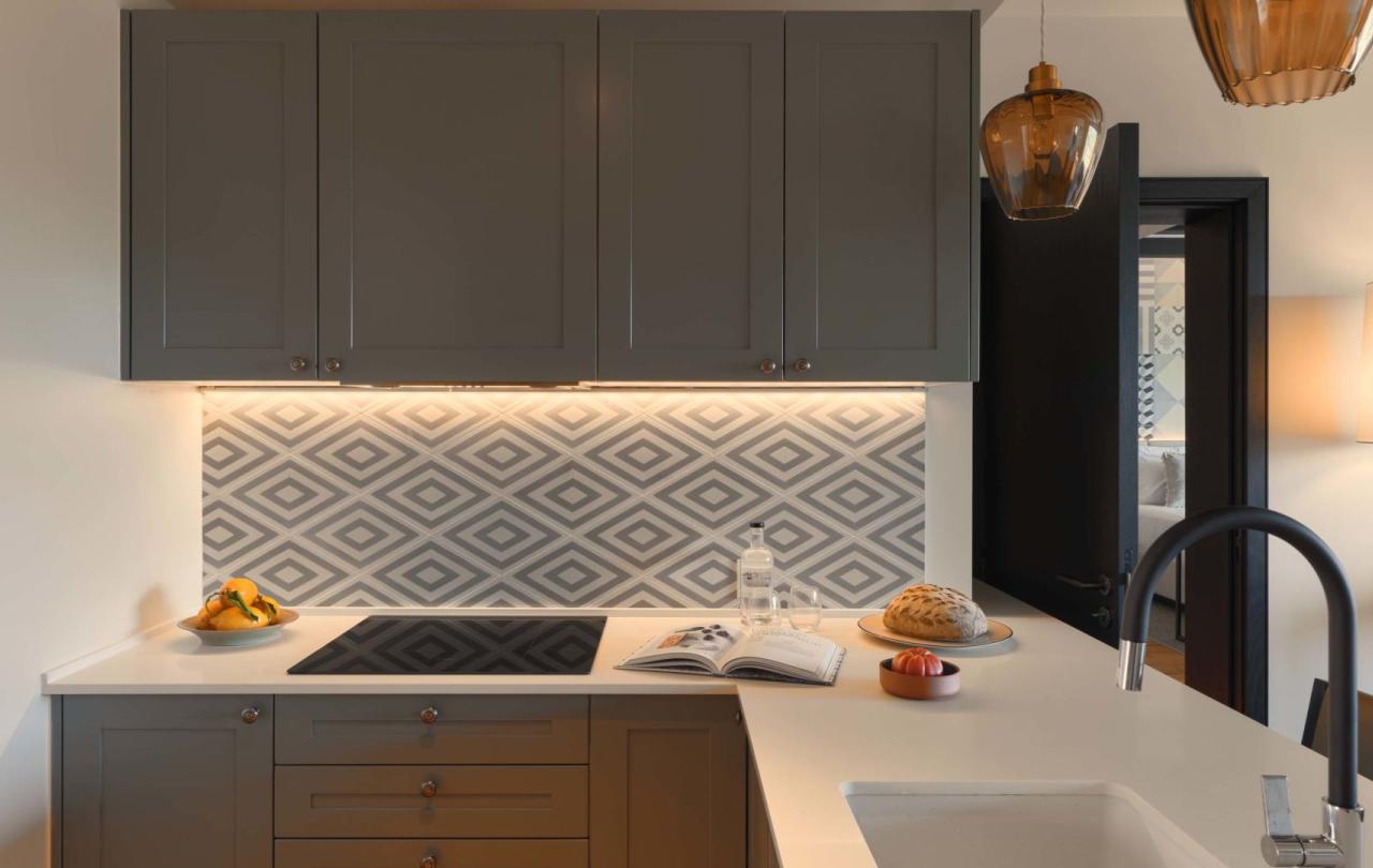 A kitchen area with sink, cook top and warm lighting in a residence at Viceroy Ombris Algarve