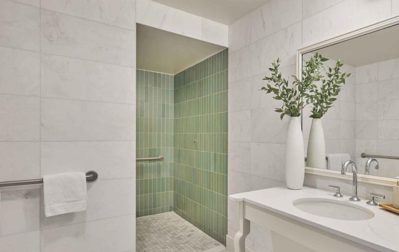 A vanity and green tiles shower in a suite at Viceroy Santa Monica