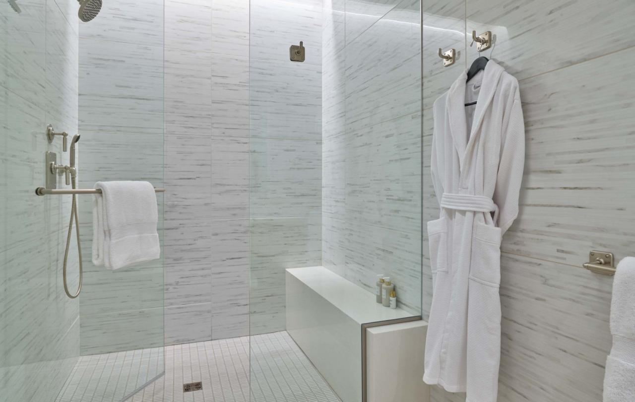 A marble bathroom with a bathrobe on a hanger