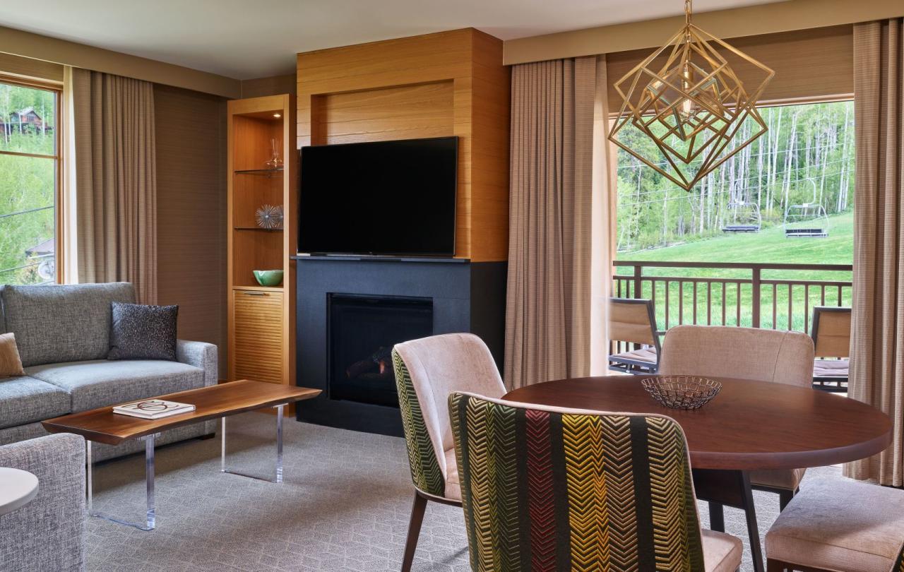 The dining and living room with a fireplace in a pinnacle two bedroom residence at Viceroy Snowmass