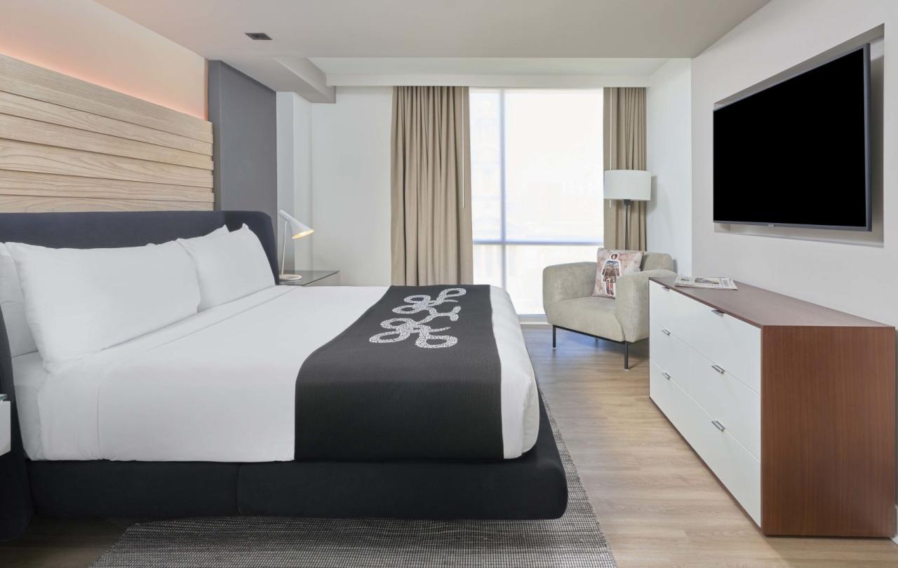 A king bed, dresser, and corner chair in a room at Viceroy Zena Washington