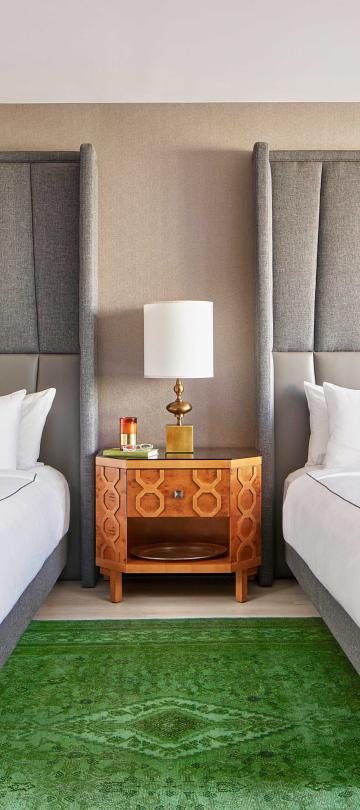 Bedroom with two queen beds and a large green carpet