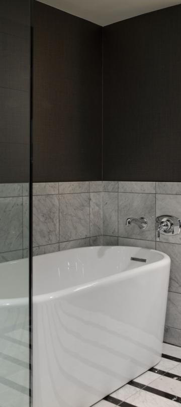 Bathroom with shower and tub separated by a glass wall