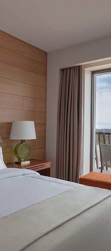 A king bed and a balcony in a suite at Viceroy Kopaonik Serbia