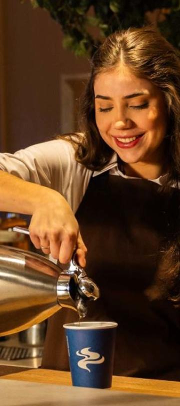 A server pours a cup of coffee at Café V