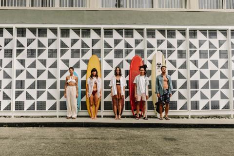A group of friends standing in front of their surf boards