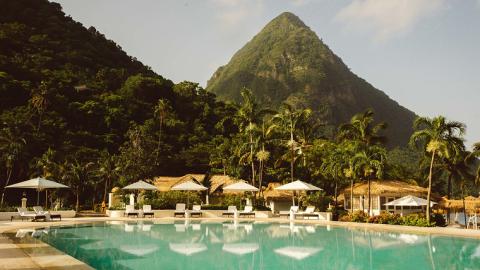 A pool and cabanas at the foot of two mountains at Sugar Beach