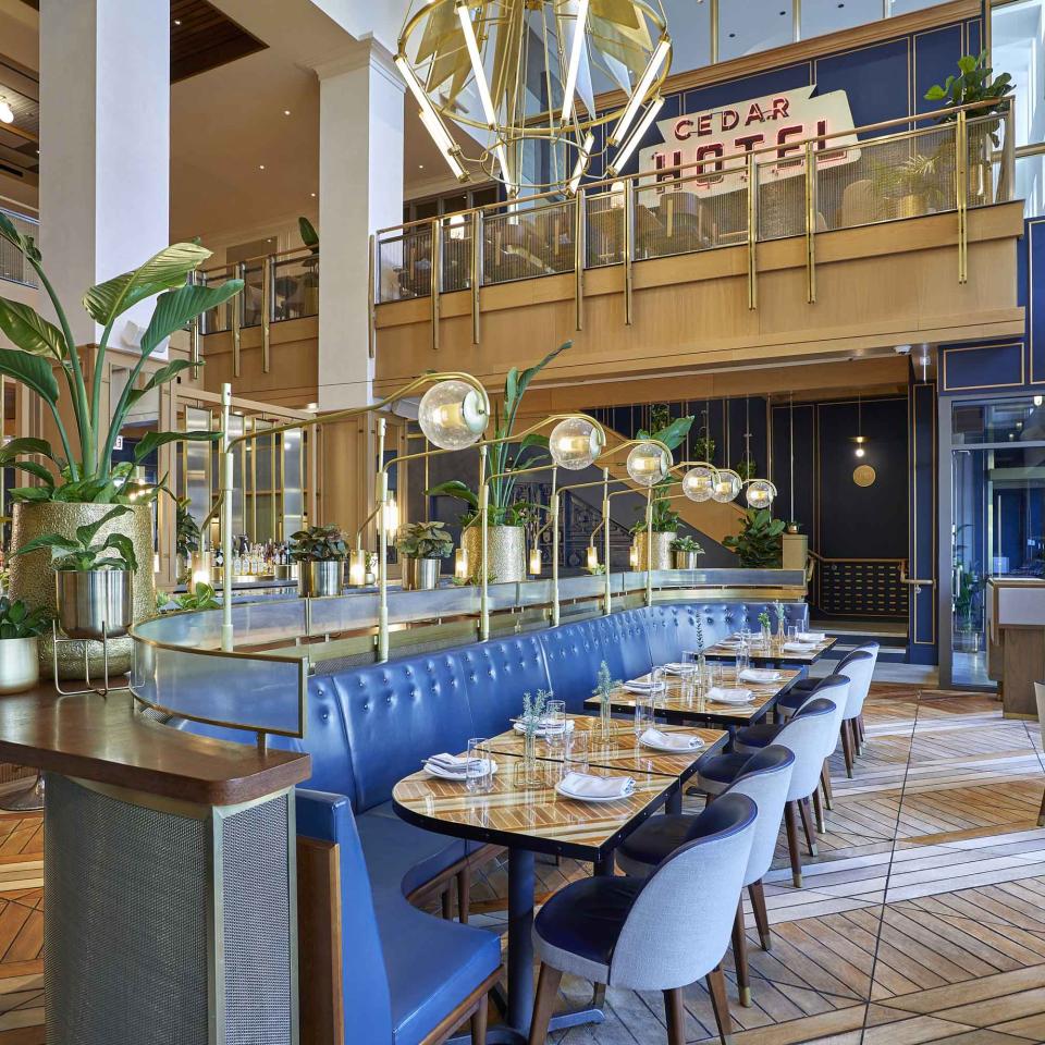 The dining room of Sommerset, Viceroy Chicago, with large blue benches and a wall-to-wall bar