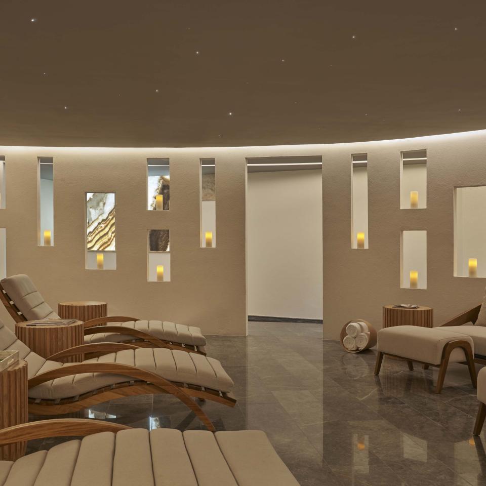 A relaxation room with comfortable recliners, lit by candle light, at the Viceroy Los Cabos spa