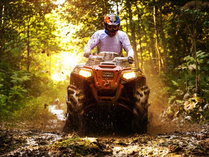 person wearing white shirt and helmet ride an ATV
