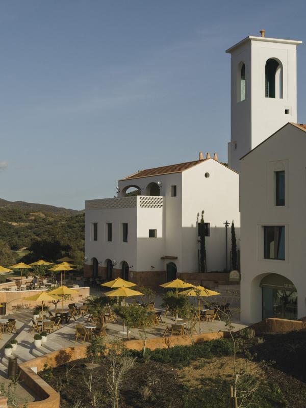 Exterior of the Viceroy Ombria Algarve Hotel with a bunch of yellow umbrellas on a shared patio space