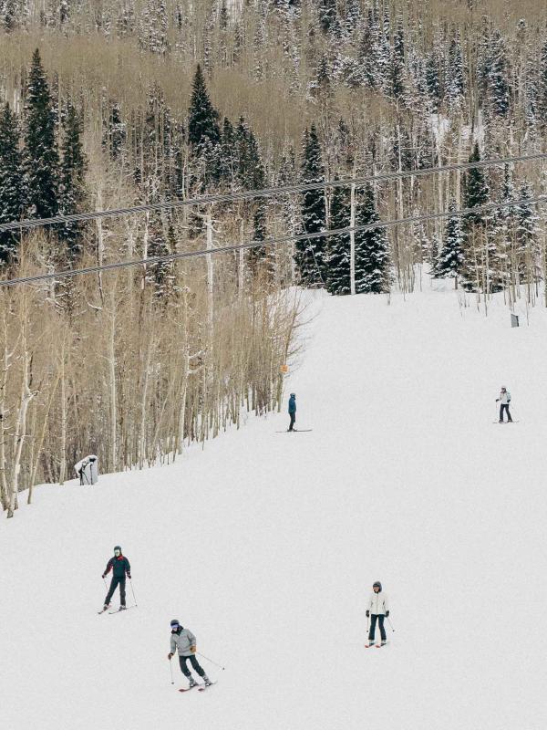 Skiers descend Snowmass mountain