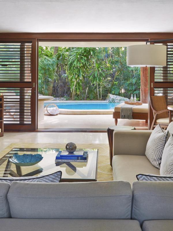 The living space with couches and chairs and a patio with a private pool at Viceroy Riviera Maya