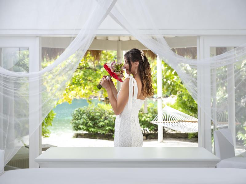 bride holds a red floral arrangement